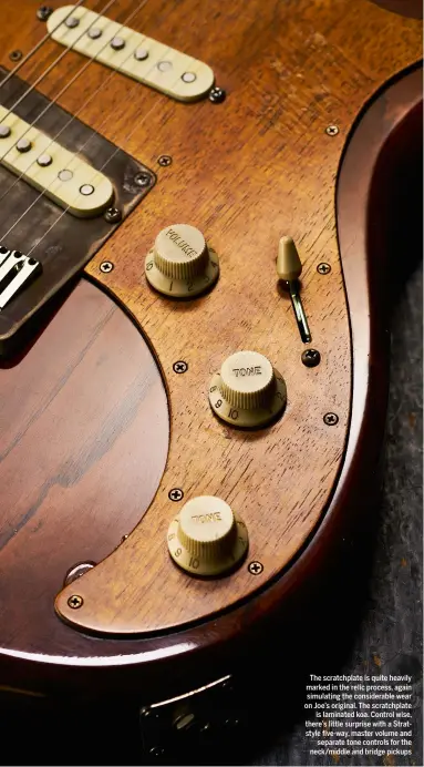  ??  ?? The scratchpla­te is quite heavily marked in the relic process, again simulating the considerab­le wear on Joe’s original. The scratchpla­te is laminated koa. Control wise, there’s little surprise with a Stratstyle five-way, master volume and separate tone controls for the neck/middle and bridge pickups