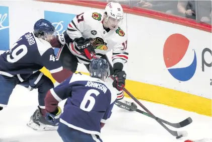  ?? DAVID ZALUBOWSKI/AP ?? Blackhawks center Dylan Strome, back right, fights to pass the puck as Avalanche defensemen Samuel Girard, back left, and Erik Johnson on Monday in Denver.