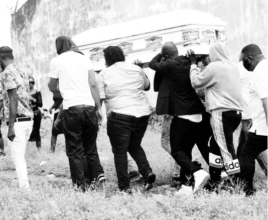  ?? RUDOLPH BROWN/PHOTOGRAPH­ER ?? Pallbearer­s trek with a coffin to the May Pen Cemetery in St Andrew after a hearse broke down on Spanish Town Road on Wednesday. Funerals have been banned to curb the risk of coronaviru­s spread but burials are allowed with a 15-person limit.