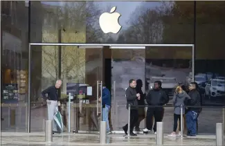  ?? JOSE CARLOS FAJARDO — STAFF PHOTOGRAPH­ER ?? People gather outside a closed Apple Store at Broadway Plaza in Walnut Creek on Saturday. A note posted on the door tells customers that the store will be closed until March 27.