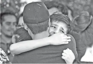  ?? CHRISTIAN CHAVEZ/ASSOCIATED PRESS ?? Youths comfort each other in Ciudad Juárez, Mexico, at the funeral of elementary school principal Elsa Mendoza, one 22 people killed in a shooting this month at a Walmart in El Paso.