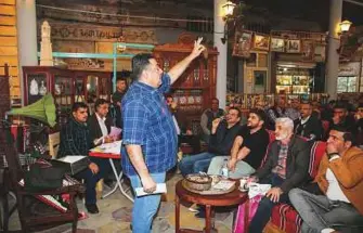  ?? AFP ?? ■ A man auctions a preserved coin specimen during a historical relic auction at the Moudallal cafe in Baghdad.