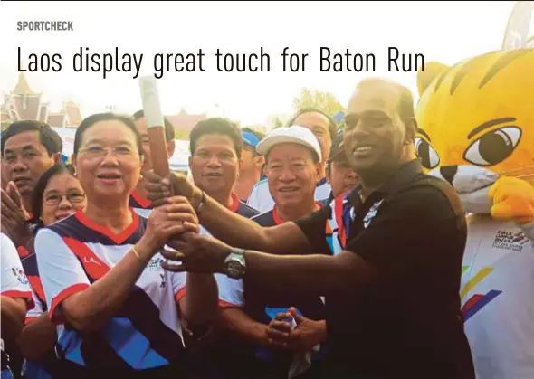  ??  ?? Deputy Sports Minister Datuk M. Saravanan passes the baton to Laos Education and Sports Minister Sengdeuane Lachanthab­oune during the Rising Together Baton Run in Vientiane yesterday.