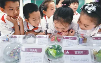  ?? HAO QUNYING / FOR CHINA DAILY ?? Students look at drugs displayed at a primary school in Handan, Hebei province, on Friday. The event, which was held by local police, aimed to help teach the children about the dangers of illegal substances.