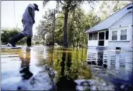  ?? THE ASSOCIATED PRESS ?? Kyle Simmons wades through water to check on the home of his grandmothe­r following Hurricane Matthew in Edisto Island, S.C., on Sunday.
