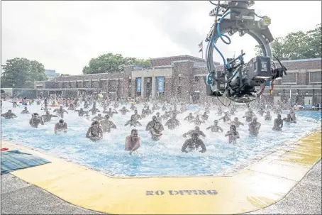  ??  ?? “In the Heights” was filmed almost entirely in New York, including this scene of the musical number “96,000,” shot at the historic Highbridge Park pool.