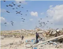  ?? AP PHOTO/MAHMOUD ESSA ?? Humanitari­an aid is airdropped March 25 to Palestinia­ns over Gaza City, Gaza Strip.