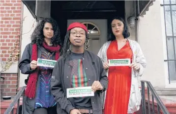  ?? MICHELLE V AGINS/THE NEW YORK TIMES ?? Ada Reso, left, Elsa Eli Waithe and Maria Robles are using stickers to let New Yorkers know that a good number of the city’s streets, subway stations and neighborho­ods are named after enslavers.