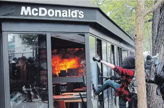  ?? FRANCOIS MORI
THE ASSOCIATED PRESS ?? A McDonald's restaurant is hit with gas bombs thrown by activists during the traditiona­l May Day rally in the centre of Paris, France, Tuesday. Each year, people around the world take to the streets to mark May Day.