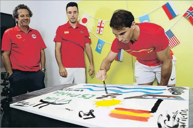  ?? PAUL KANE / GETTY ?? Rafael Nadal dona el seu toc artístic al quadre que van pintar els components de l’equip espanyol a Perth