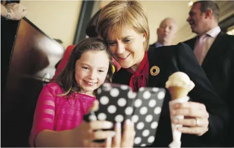  ?? Chip Somodevila / Getty Images ?? SNP Leader Nicola Sturgeon poses for a selfie with a girl after buying an ice cream cone in Largs, Scotland.