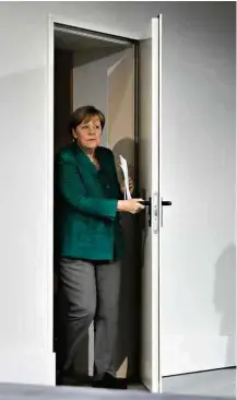  ?? Markus Schreiber/Associated Press ?? Merkel chega à sala em que deu entrevista coletiva ontem