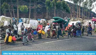  ?? — AFP ?? GOMA: War-displaced people flee towards the city of Goma, eastern Republic of Congo. Thousands of displaced people began to flee after soldiers retreated to Kanyarushi­nya, an informal camp of over 40,000 people in the northern district of Goma.