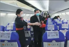  ?? CHENG MIN / XINHUA ?? A China Eastern Airlines’ stewardess guides a passenger to his seat before the takeoff at Wuhan Tianhe Internatio­nal Airport in Wuhan on April 8.