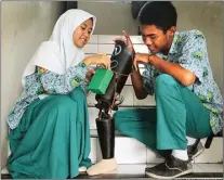  ?? CHANDRA SATWIKA/JAWA POS ?? LEBIH MUDAH BERGERAK: M. Almas Bukhori dan Widya Widati mengutak-atik kaki palsu yang dilengkapi dengan sensor flex pada pangkal kaki kemarin.