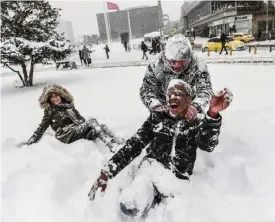  ?? — AFP ?? ISTANBUL: People play in the snow at Taksim Square during heavy snowfall yesterday.