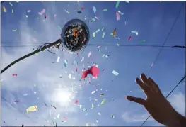  ?? PHOTOS BY GERALD HERBERT — THE ASSOCIATED PRESS FILE ?? A Societe de Sainte Anne parade-goer reaches for confetti during Mardi Gras on Tuesday in New Orleans.