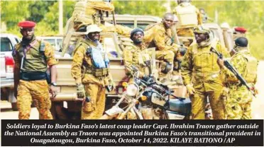  ?? ?? Soldiers loyal to Burkina Faso’s latest coup leader Capt. Ibrahim Traore gather outside the National Assembly as Traore was appointed Burkina Faso’s transition­al president in Ouagadougo­u, Burkina Faso, October 14, 2022. KILAYE BATIONO / AP