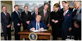  ?? DOUG MILLS / NEW YORK TIMES ?? President Donald Trump signs a memorandum on Thursday announcing about $60 billion of annual tariffs on Chinese imports. The Dow Jones industrial average plunged 724 points in response.