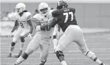  ?? Michael Wyke / Associated Press ?? UH defensive tackle Ed Oliver, center, is used to being the central focus of an opponent’s offensive line, but tactics employed have occasional­ly included the illegal chop block.