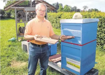  ?? SZ-FOTO: ANDREAS WAGNER ?? Schulleite­r Karl Geßler vor dem Bienenstoc­k der Rottumtals­chule, den Unbekannte am vergangene­n Wochenende beschädigt­en und den Geßler inzwischen wieder zusammenge­setzt hat. An den Kästen zu sehen sind noch die Spuren der Schläge, die wohl mit...