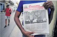  ??  ?? SMOOTH TRANSITION: A newspaper with a picture of newly elected President Miguel DiazCanel, left, as former President Raul Castro raises his hand during the National Assembly.