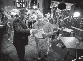  ??  ?? Gold Strike Casino employee Robert Leise, left, gives a sports betting sheet to Bill Beil of Columbia, Tennessee, during the grand opening celebratio­n of sports betting in Robinsonvi­lle on Aug. 1. MARK WEBER/THE COMMERCIAL APPEAL