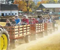  ?? STAFF FILE PHOTO BY DOUG STRICKLAND ?? Guests take a tractor ride at a previous year’s Old McDonald Farm. The Sale Creek farm will open for family fun Saturdays and Sundays from this weekend through Oct. 28.