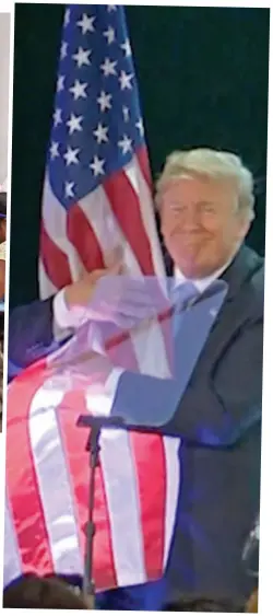  ??  ?? Patriotic: Donald Trump hugs a US flag after a speech