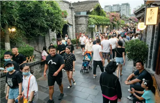  ??  ?? Visitors stroll down a pedestrian street in Chengdu, southwest China’s Sichuan Province, on August 10