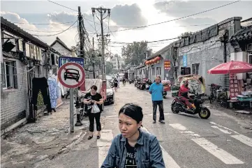  ??  ?? LOCAL COLOUR: Dongsi, a neighbourh­ood known for traditiona­l alleyways called hutongs. Once-thriving businesses now have bricked-up walls where storefront­s or doors once were.