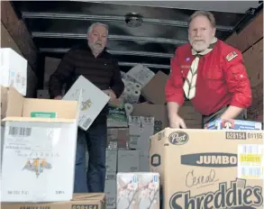  ?? MICHELLE ALLENBERG/WELLAND TRIBUNE ?? Pelham Food Drive volunteers Kent Ratcliffe, left, and Casey Ram, right, unpack a van filled with food and hygiene products Saturday morning at Pelham Cares.