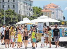  ?? FOTO: MARKO DIMIC/PIXSELL/XINHUA/DPA ?? Touristen spazieren an der Uferpromen­ade im kroatische­n Zadar entlang. Laut Robert-Koch-Institut bringen derzeit immer mehr Reiserückk­ehrer das Coronaviru­s mit nach Deutschlan­d.