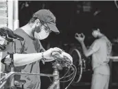  ?? Marie D. De Jesús / Staff photograph­er ?? Rice Bikes mechanic Danny Moloo, 19, works on a bicycle while wearing a mask Monday.