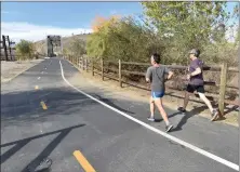  ?? Dan Watson/The Signal ?? Runners use the paseo near the Iron Horse Trail head in Valencia on Tuesday.