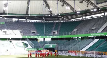  ?? KAI PFAFFENBAC­H — POOL PHOTO VIA AP ?? Munich’s players celebrate in front of the empty stands after the German Bundesliga soccer match between VfL Wolfsburg and FC Bayern Munich in Wolfsburg, Germany, June 27.