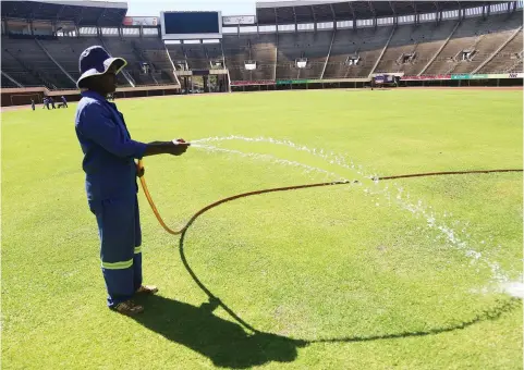  ??  ?? GREEN GRASS OF HOME . . . A worker waters the pitch, which looks in pristine shape, at the National Sports Stadium yesterday