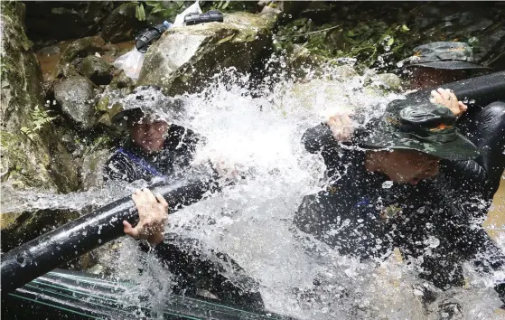  ?? FOTO: TT/AP/SAKCHAI LALIT ?? Thailändsk­a soldater pumpar ut vatten från grottorna. De har lyckats sänka nivån så mycket att det bara är korta sträckor kvar där pojkarna blir tvungna att dyka.