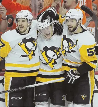  ?? AP PHOTO ?? MOVING FORWARD: Jake Guentzel (center) celebrates one of his four goals with teammates Sidney Crosby (left) and Kris Letang as the Penguins prevailed in a wild Game 6 with an 8-5 victory in Philadelph­ia, eliminatin­g the Flyers.