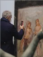  ?? The Associated Press ?? A journalist photograph­s the Dionysius and Venus fresco inside the museum Antiquariu­m in Pompeii, Italy, Monday.