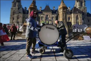  ?? (AP/The Canadian Press/Justin Tang) ?? Protesters bang on both sides of a bass drum Monday in an effort to make a noise that will reach politician­s in West Block on Parliament Hill in Ottawa, Ontario.