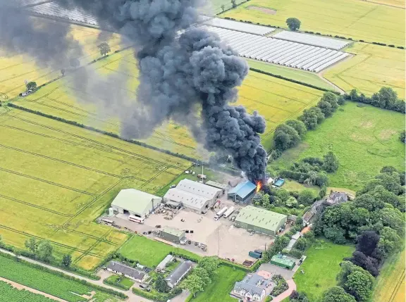  ??  ?? A drone shot of the fire at Rosemount Farm on Saturday shows the extent of the smoke and flames after the major outbreak in a building.