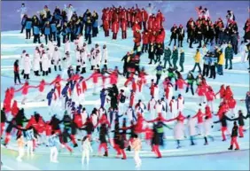  ?? ?? Athletes dance in a circle as they enter the stadium during the closing ceremony of the Beijing Winter Olympics.