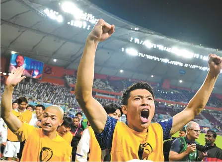  ?? Korea Times photo by Choi Won-suk ?? Japanese players celebrate after winning the World Cup Group E football match against Germany at the Khalifa Internatio­nal Stadium in Doha, Qatar, Wednesday. Japan beat Germany 2-1.