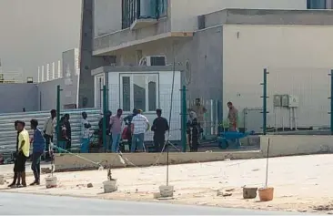  ?? AP ?? Migrants line up Wednesday outside a facility operated by the United Nations refugee agency, UNHCR, in Tripoli, Libya. It’s one of the few safe places for migrants in the war-torn country, where militias and trafficker­s take advantage of their desperatio­n.