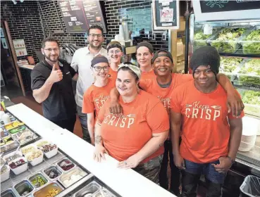  ?? ?? Grassroots Salad Company owners Peter Liapis, left, and Louis Liapis pose with their employees, from lower center clockwise, Cierra Wood, Kari Toth, Taylor Towery, Faith Roark, Ashanti Whitfield and Armond Seals at the Grassroots restaurant in the Chase Tower on North Water Street in Milwaukee.