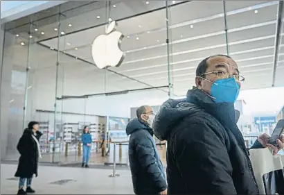  ?? ANDRE PICHETTE / EFE ?? Ciudadanos pasean con mascarilla ante una tienda de Apple cerrada en Montreal