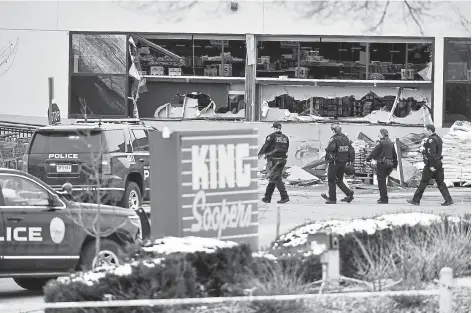  ?? Helen H. Richardson, The Denver Post ?? Law enforcemen­t officers wait outside the broken windows at the front of the King Soopers on Monday as they respond to the shooting.