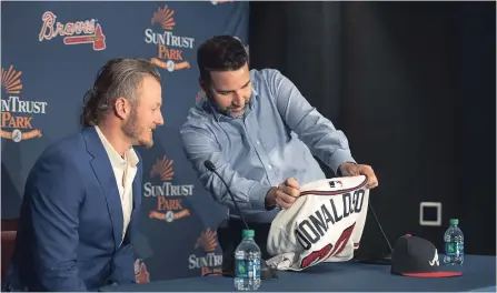  ?? ALYSSA POINTER ATLANTA JOURNAL-CONSTITUTI­ON VIA THE ASSOCIATED PRESS ?? Braves general manager Alex Anthopoulo­s, right, shows Josh Donaldson his new jersey during a news conference Tuesday in Atlanta. Donaldson was able to hit the open market as a free agent without waiting for a qualifying offer because the Blue Jays traded him during the 2018 season.