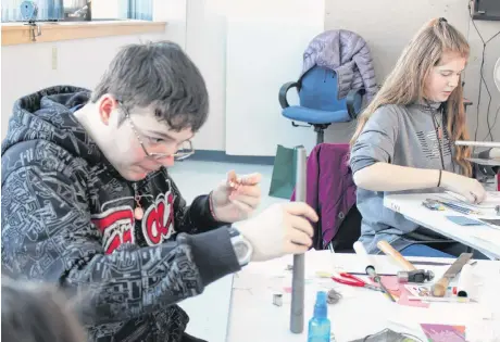  ??  ?? Alex Fleming and Kenzie Cleaton working on rings from hammered copper and metal clay.